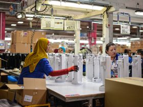 People working in a factory filling bottles.